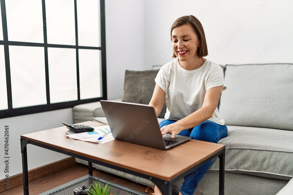 Middle age hispanic woman using laptop doing domestic finances at home Middle age hispanic woman using laptop doing domestic finances at home