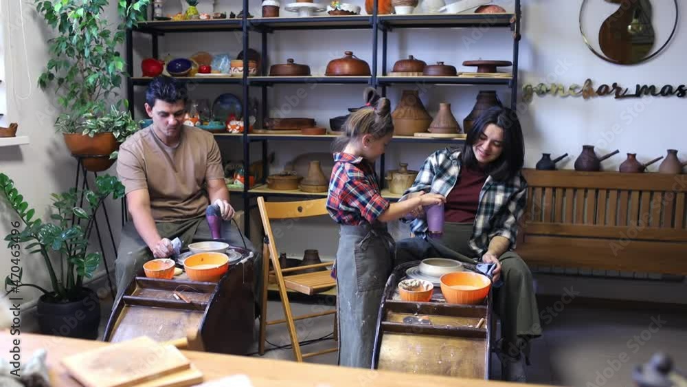 a young family with their daughter dries clay cups with a hairdryer, at a pottery master class a young family with their daughter dries clay cups with a hairdryer, at a pottery master class
