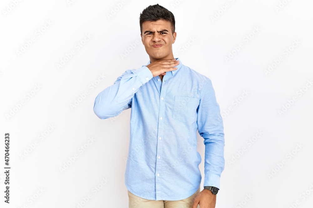 Young hispanic man wearing business shirt standing over isolated background cutting throat with hand as knife, threaten aggression with furious violence Young hispanic man wearing business shirt standing over isolated background cutting throat with hand as knife, threaten aggression with furious violence