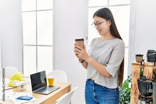 Young asian woman drinking take away coffee at the office