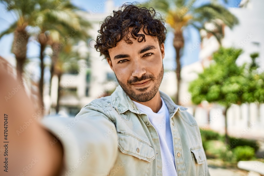 Handsome hispanic man with beard smiling happy outdoors on a sunny day Handsome hispanic man with beard smiling happy outdoors on a sunny day