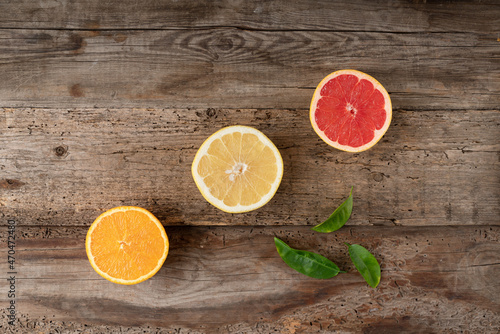 Fototapeta Naklejka Na Ścianę i Meble -  Citruses on a wooden background. Cut fruit. Juicy grapefruit and orange. View from above