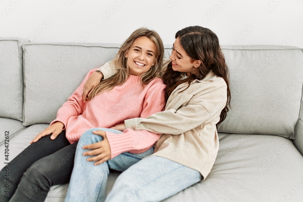 Young beautiful couple sitting on the sofa hugging at home. Young beautiful couple sitting on the sofa hugging at home.