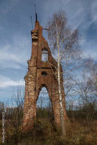 Brick remains of an old abandoned bell tower. An old abandoned brick structure in the forest. Brick wall.