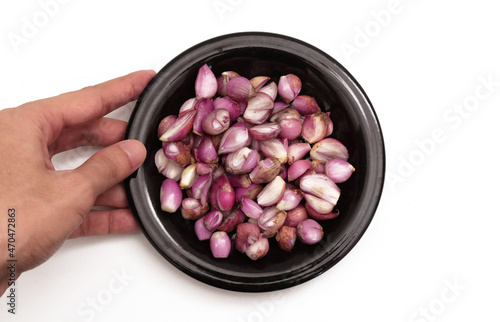 Hand holding onion on black plate