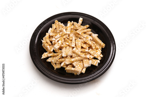 fermented soybeans that have been cut into small pieces on a black plate