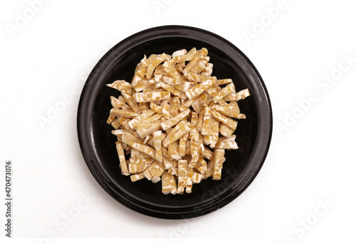 fermented soybeans that have been cut into small pieces on a black plate