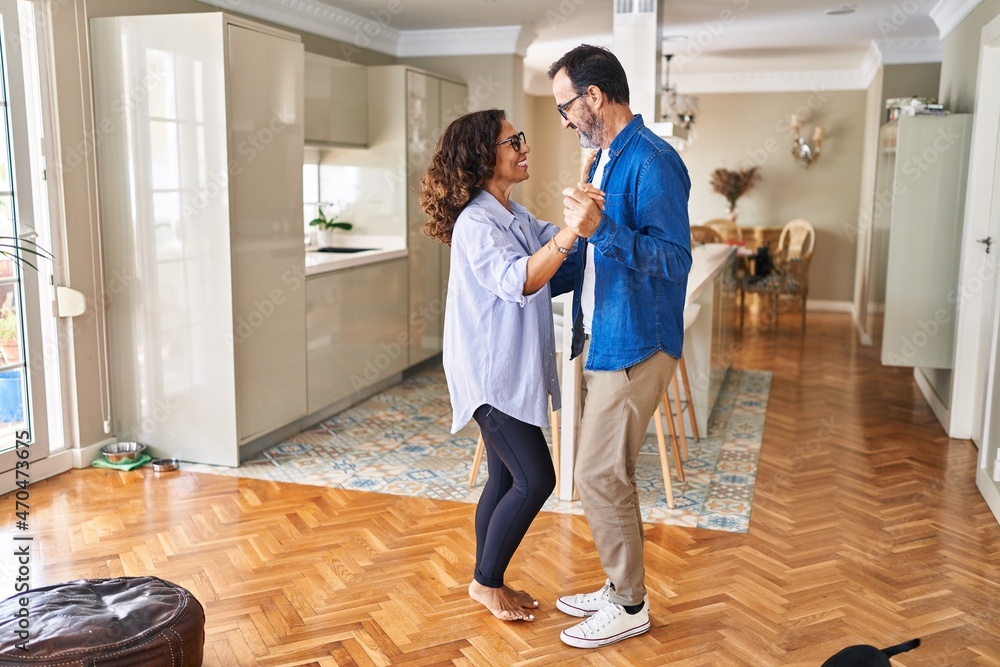 Middle age hispanic couple smiling confident dancing at home Middle age hispanic couple smiling confident dancing at home