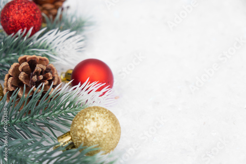 Christmas composition of Christmas tree toy red and gold ball snow background tree branch cone