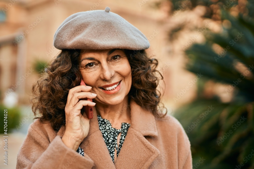 Middle age hispanic woman smiling happy talking on the smartphone at the city.