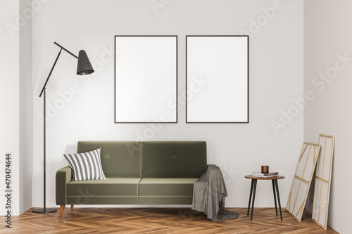 Two empty canvases on light beige wall and green sofa © ImageFlow