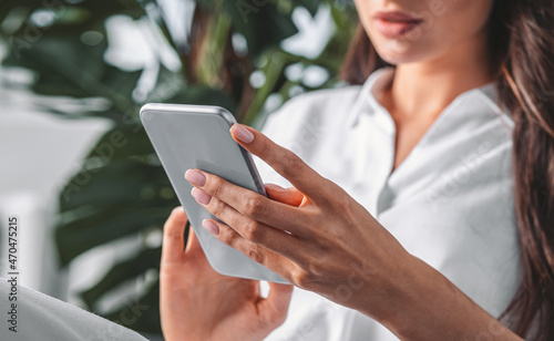 Businesswoman hands using smartphone, closeup, white shirt