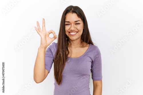 Wallpaper Mural Young brunette woman standing by isolated background smiling positive doing ok sign with hand and fingers. successful expression. Torontodigital.ca