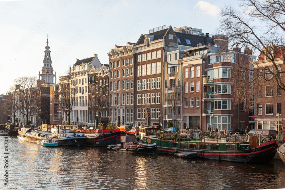 Canal in the old city of Amsterdam with traditional houseboats in a winter day, Netherlands.