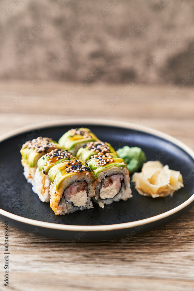 Plate of shrimp and cheese cream uramaki sushi on a wooden surface Plate of shrimp and cheese cream uramaki sushi on a wooden surface