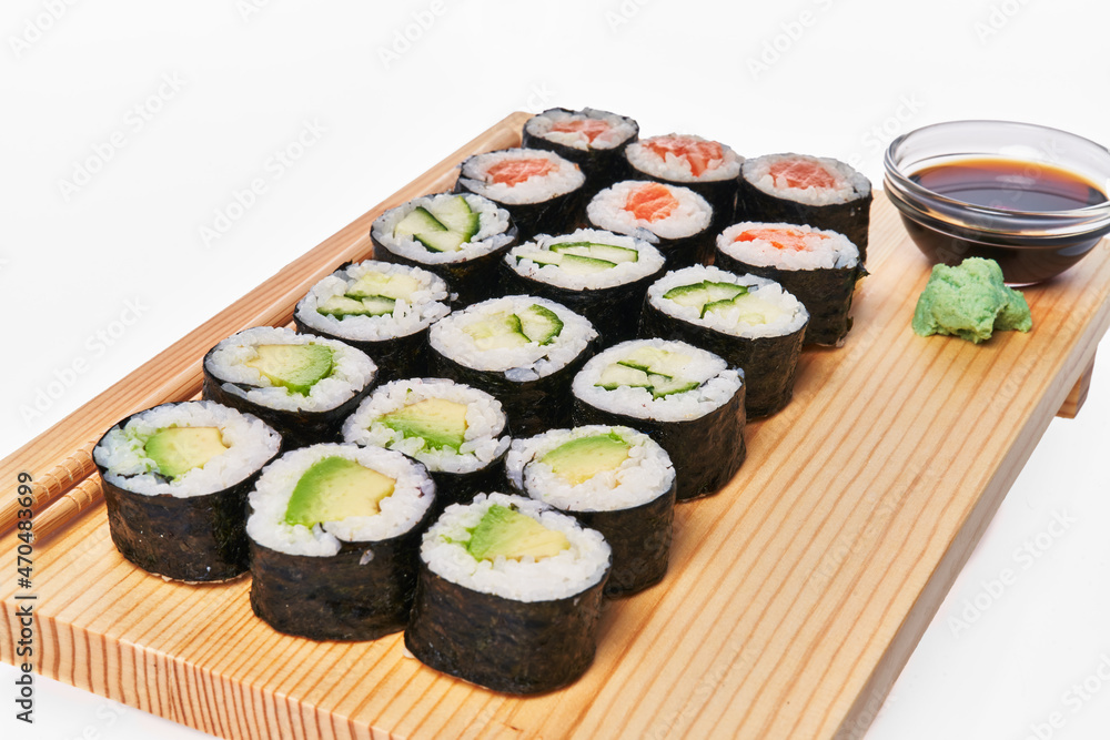 Wooden board with avocado, salmon and cucumber sushi makis isolated on white background Wooden board with avocado, salmon and cucumber sushi makis isolated on white background
