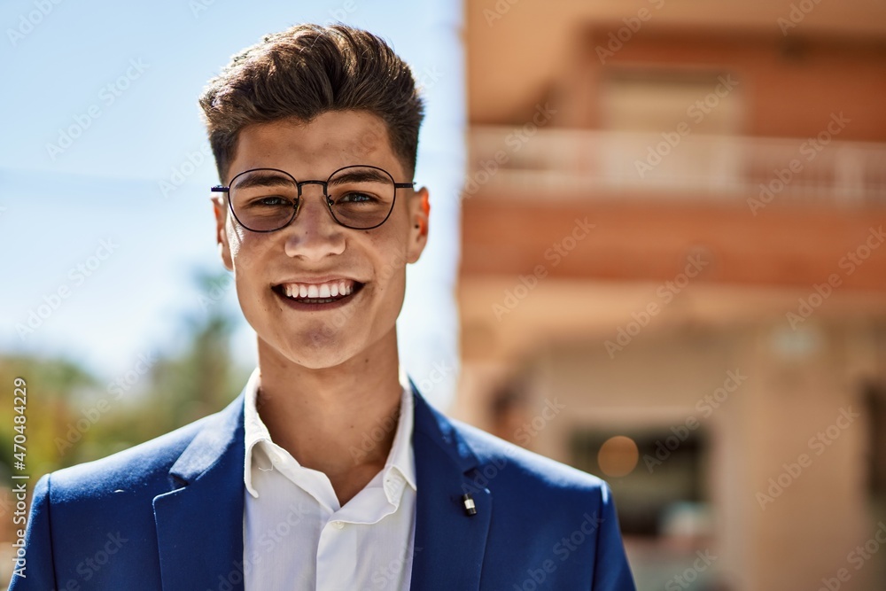 Obraz premium Young man smiling confident wearing suit and glasses at street