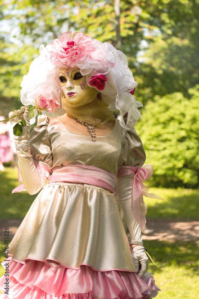 Venetian Carnival. Woman in pink dress and facemask