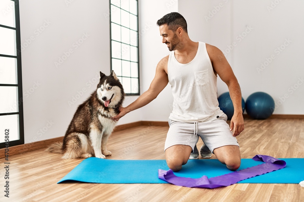 Young hispanic man smiling confident playing with dog at sport center Young hispanic man smiling confident playing with dog at sport center