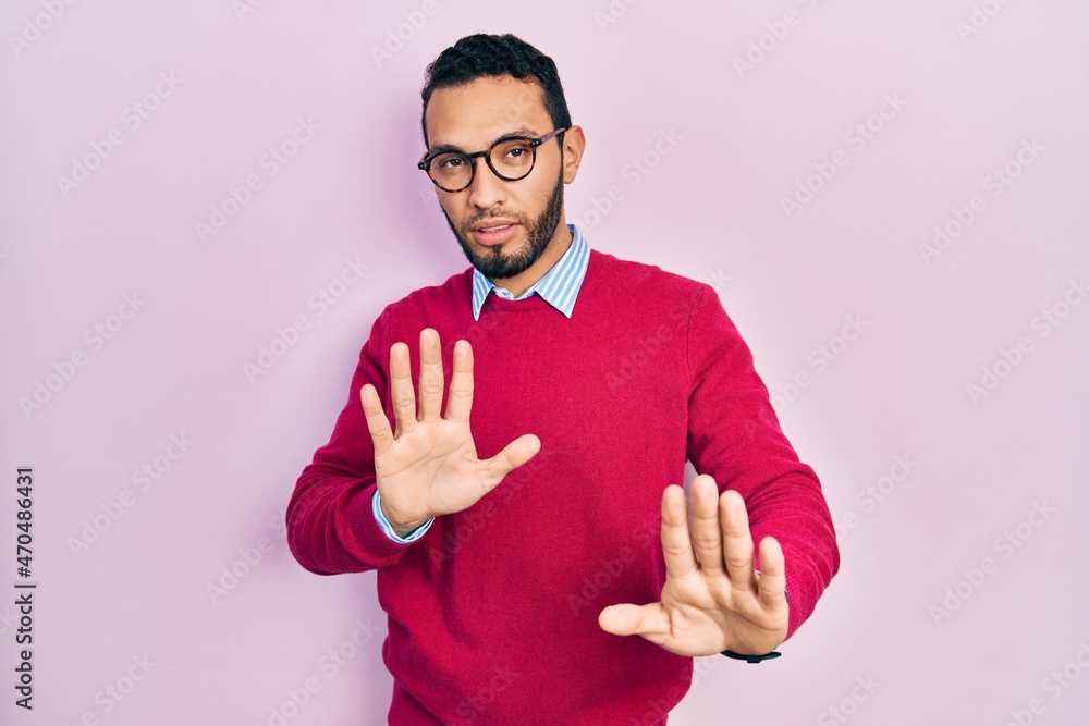 Hispanic man with beard wearing business shirt and glasses moving away hands palms showing refusal and denial with afraid and disgusting expression. stop and forbidden. Hispanic man with beard wearing business shirt and glasses moving away hands palms showing refusal and denial with afraid and disgusting expression. stop and forbidden.