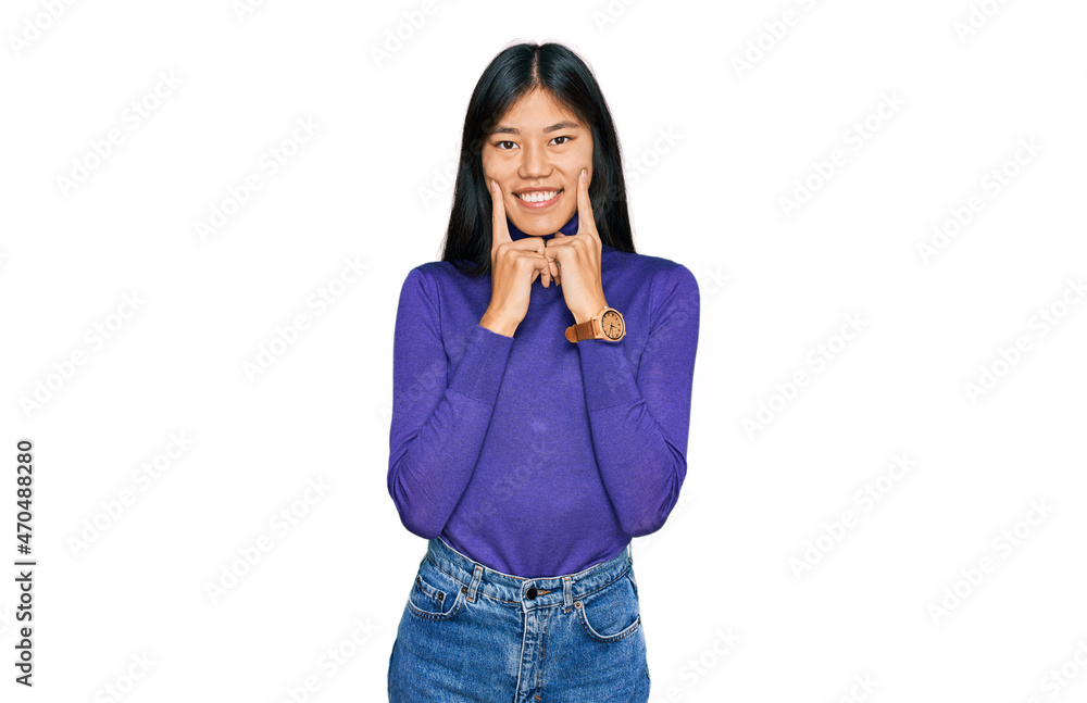 Beautiful young asian woman wearing casual clothes smiling with open mouth, fingers pointing and forcing cheerful smile Beautiful young asian woman wearing casual clothes smiling with open mouth, fingers pointing and forcing cheerful smile