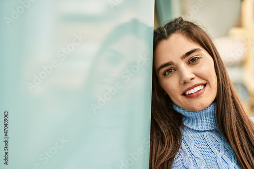 Young hispanic girl smiling happy standing at the city