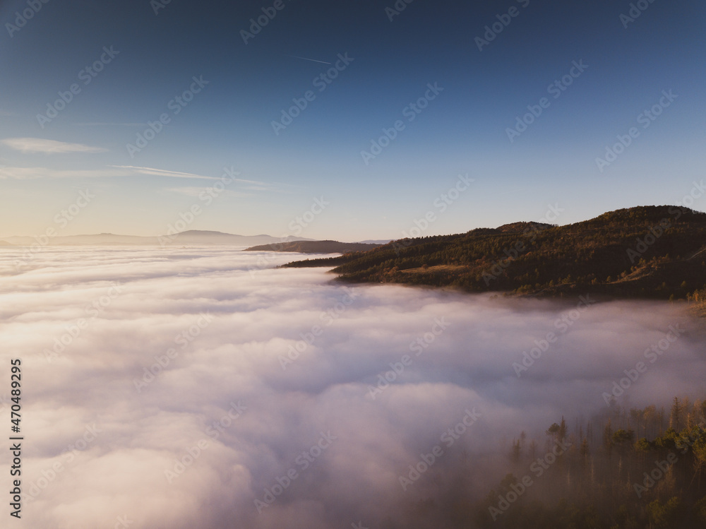Obraz premium Italy November 2021: aerial view of mountains with fog below in autumn season at sunset