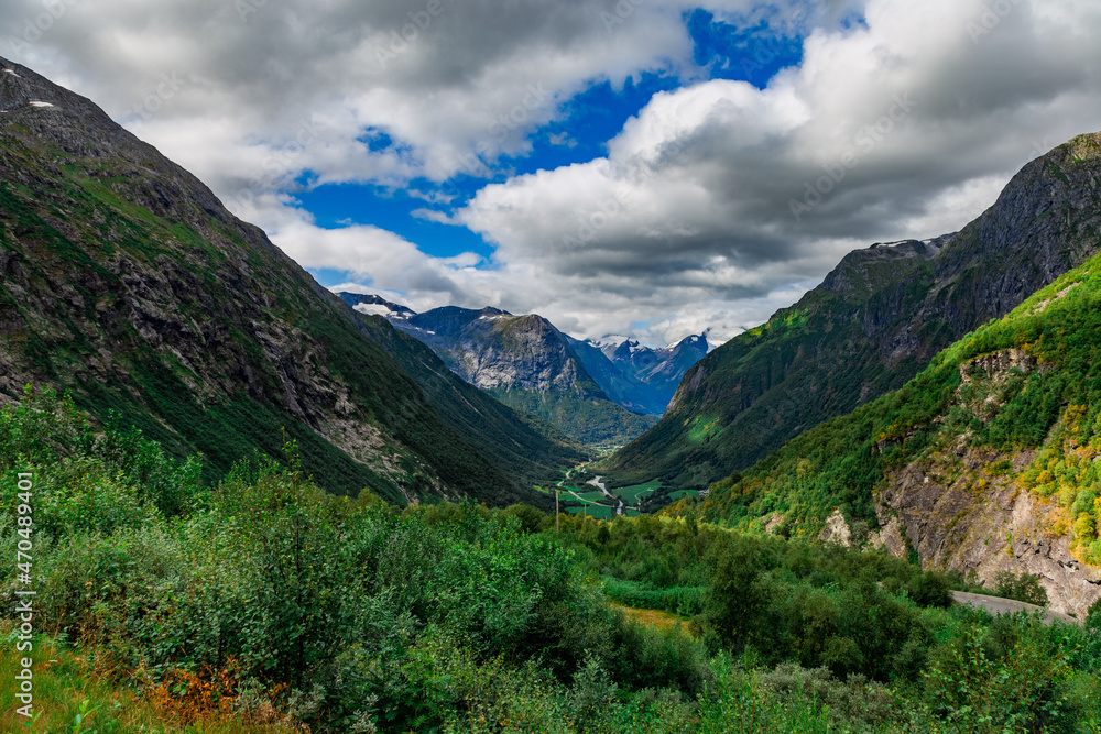 Scenic view from the road on a the valley between beautiful Norwegian mountains against  dramatic cloudy sky
