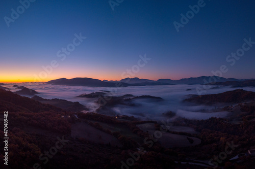 Italy November 2021  aerial view of mountains with fog below in autumn season at sunset