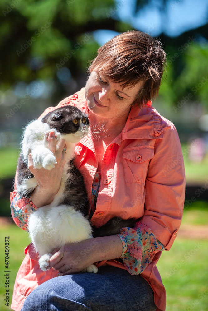 portrait of a cat in the arms of a woman portrait of a cat in the arms of a woman