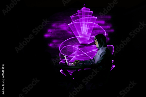 Man using technology with laptop. Abstract purple light form in the background, made to lightpainting. 
