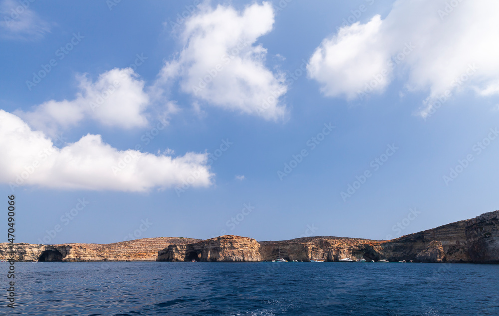 Pleasure boats near coastal caves of the Blue Lagoon, Malta