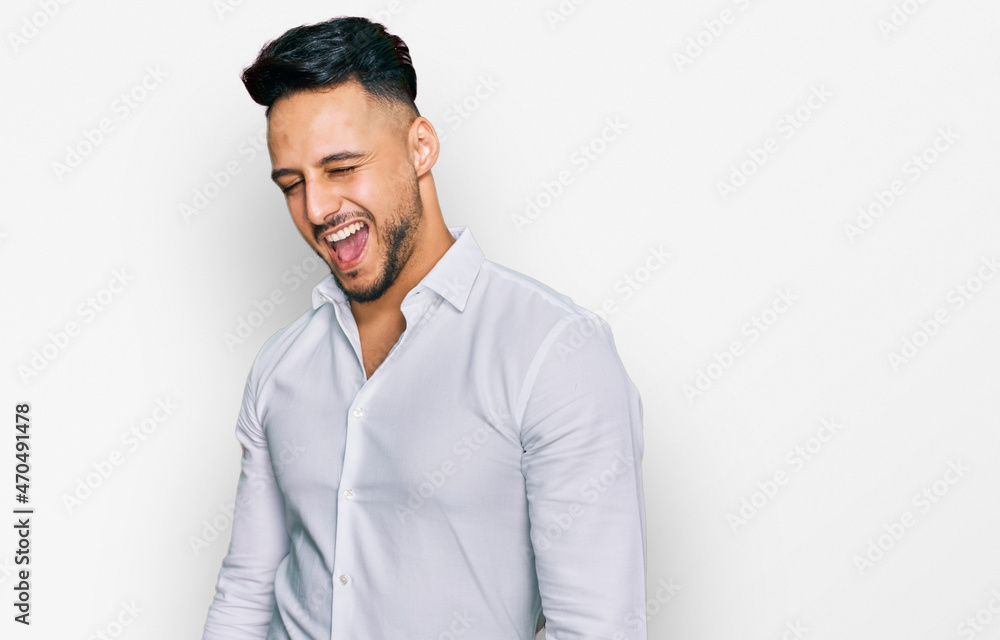Young arab man wearing casual clothes winking looking at the camera with sexy expression, cheerful and happy face. Young arab man wearing casual clothes winking looking at the camera with sexy expression, cheerful and happy face.