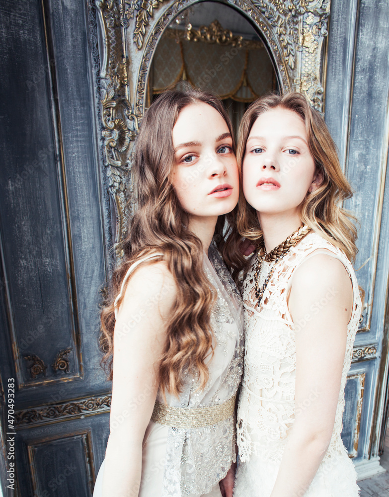 two pretty twin sister blond curly hairstyle girl in luxury house interior together, rich young people concept two pretty twin sister blond curly hairstyle girl in luxury house interior together, rich young people concept