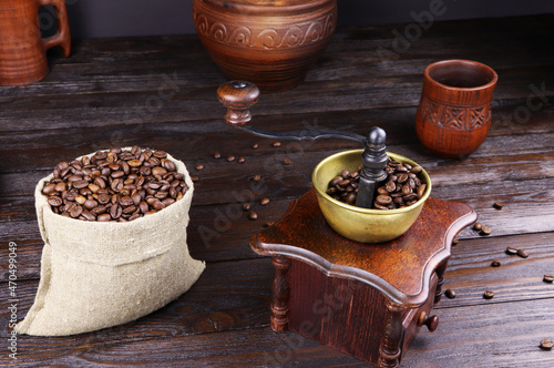 Coffee beans are poured into a coffee grinder. Coffee beans on a wooden table. Grinding of coffee beans.