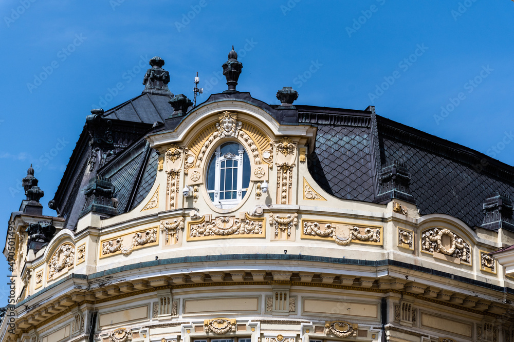 The old roof and the attic of the town hall on the blue sky background. Sibiu, Romania.