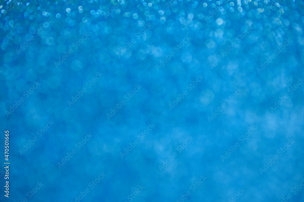 Glitter blue background. Texture foil and confetti bokeh, light of blue dust. Festive party Christmas and new year's eve background. Glitter blue background. Texture foil and confetti bokeh, light of blue dust. Festive party Christmas and new year's eve background.