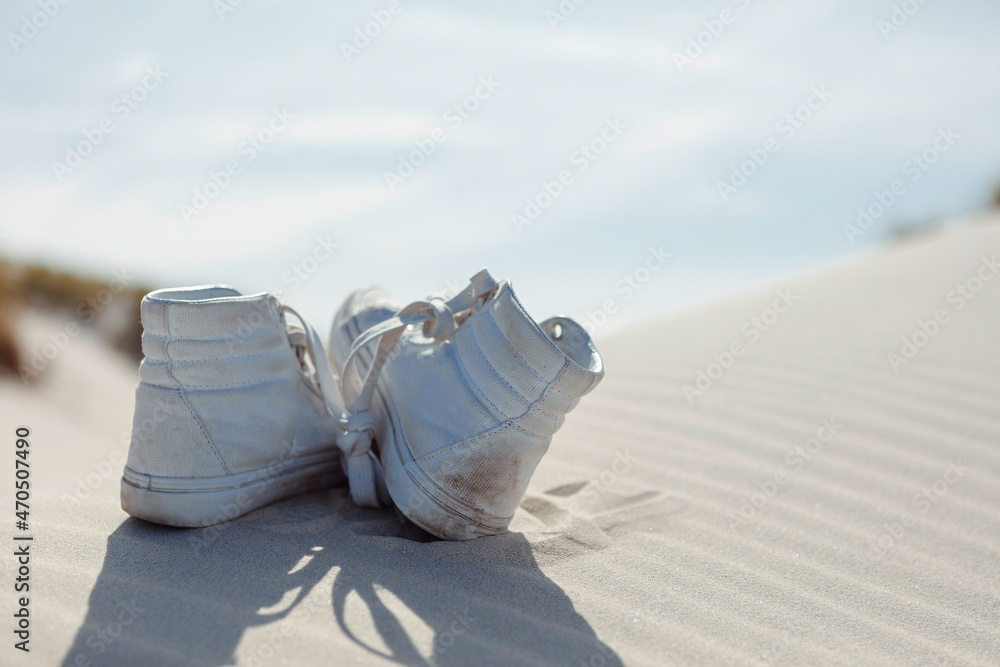 Back view of ankle shoes pair on sand. Selective focus. Back view of ankle shoes pair on sand. Selective focus.