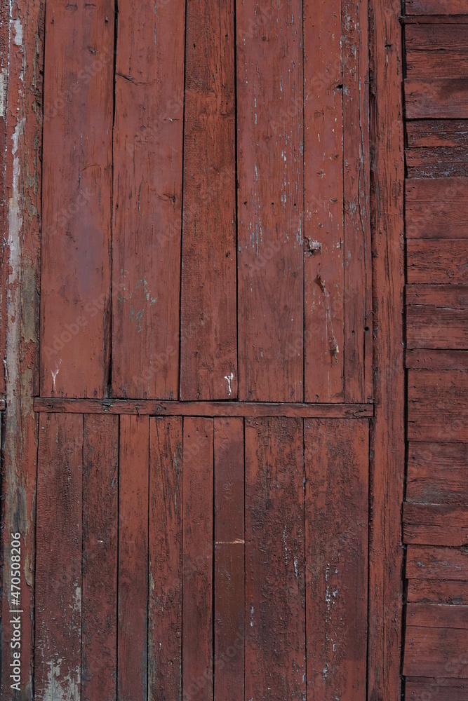 Old wooden wall with remnants of red paint. Texture of old wooden boards. Old wooden wall with remnants of red paint. Texture of old wooden boards.