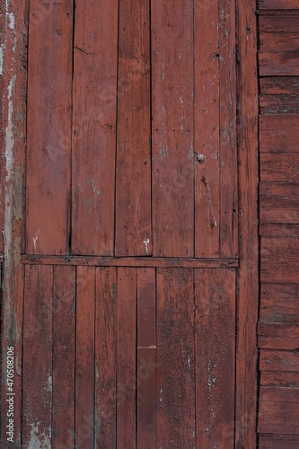 Old wooden wall with remnants of red paint. Texture of old wooden boards.