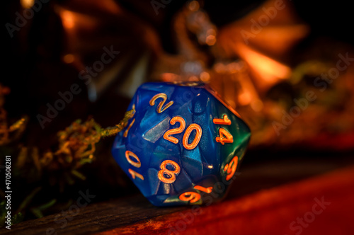 Close-up image of a blue d20 in warm light