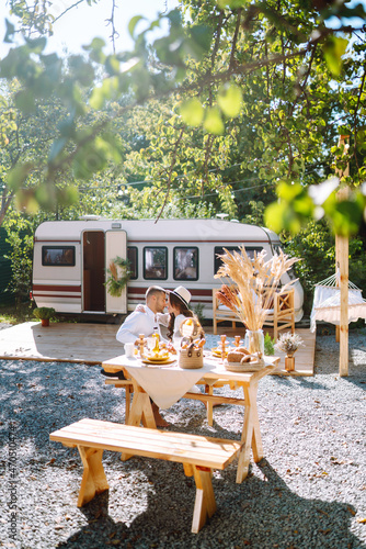 Happy newlyweds elaxing in rv, camping in a trailer. Couple embracing each other and smiling. Romantic moment. Together. Wedding. Marriage. photo