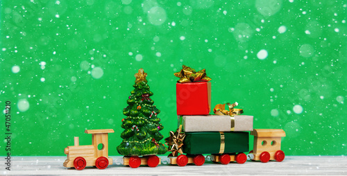 Merry Christmas and happy New Year card celebration background with wooden train full Christmas presents box and tree
