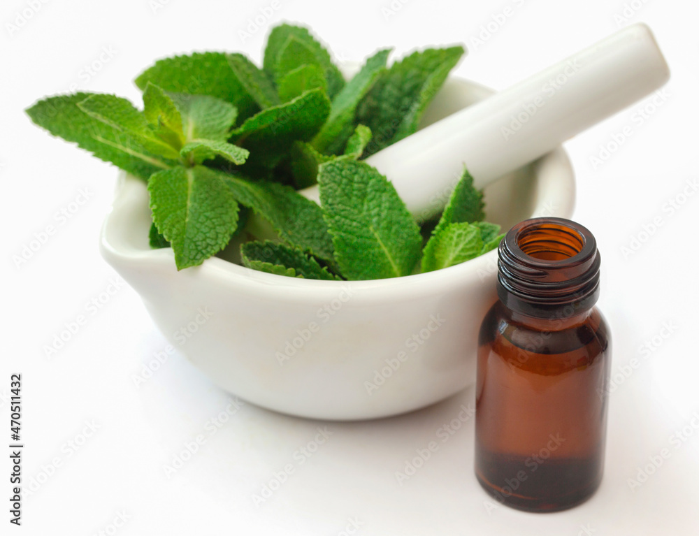 Mint leaves with essential oil in a bottle