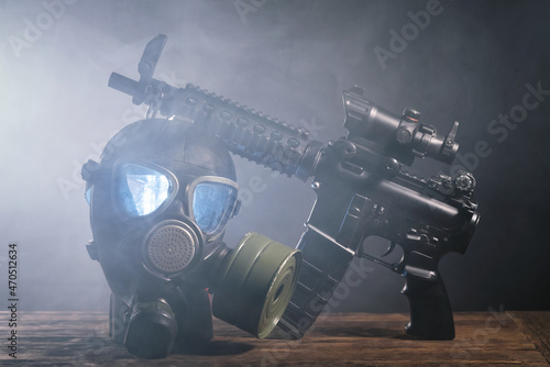 Rifle and gas mask on the table in the gas background. Special force equipment concept.