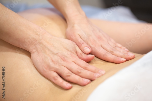 Hands of woman masseur on back of patient