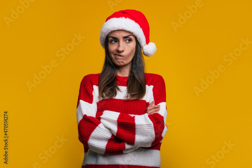 Don\'t like this Christmas. Close up portrait of an unhappy and sad cute young woman with crossed arms