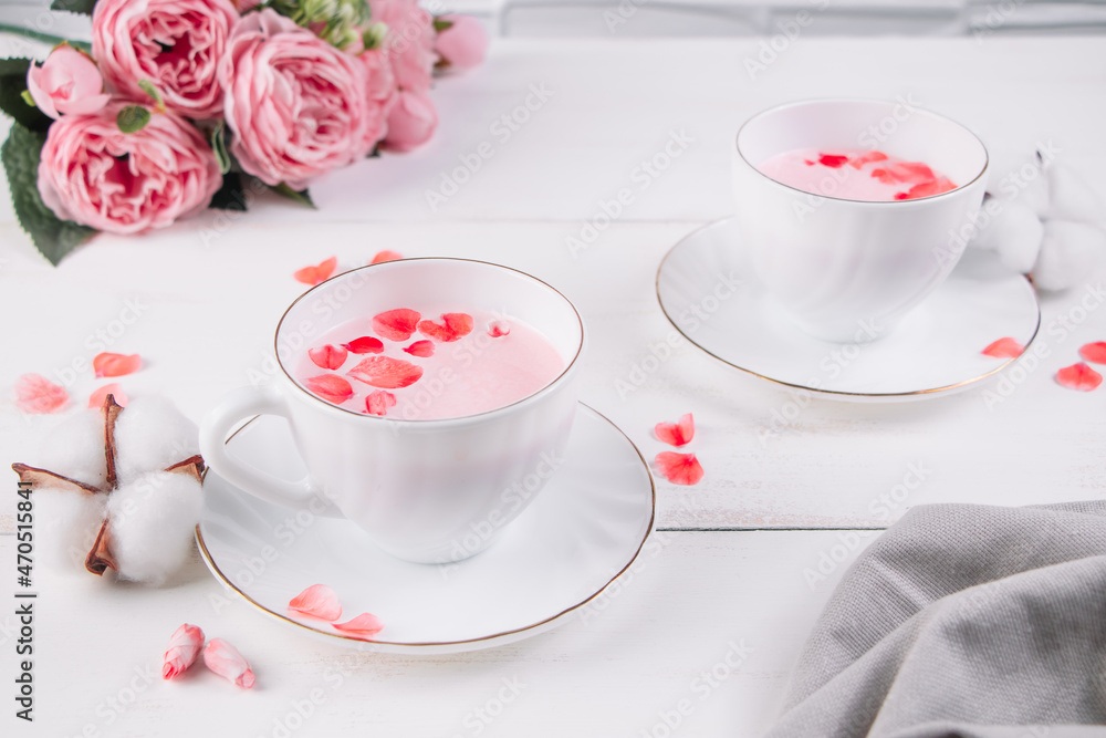 Two cups of pink matcha. Relaxing drink to improve sleep. Trendy vegan tea on white background. Two cups of pink matcha. Relaxing drink to improve sleep. Trendy vegan tea on white background.