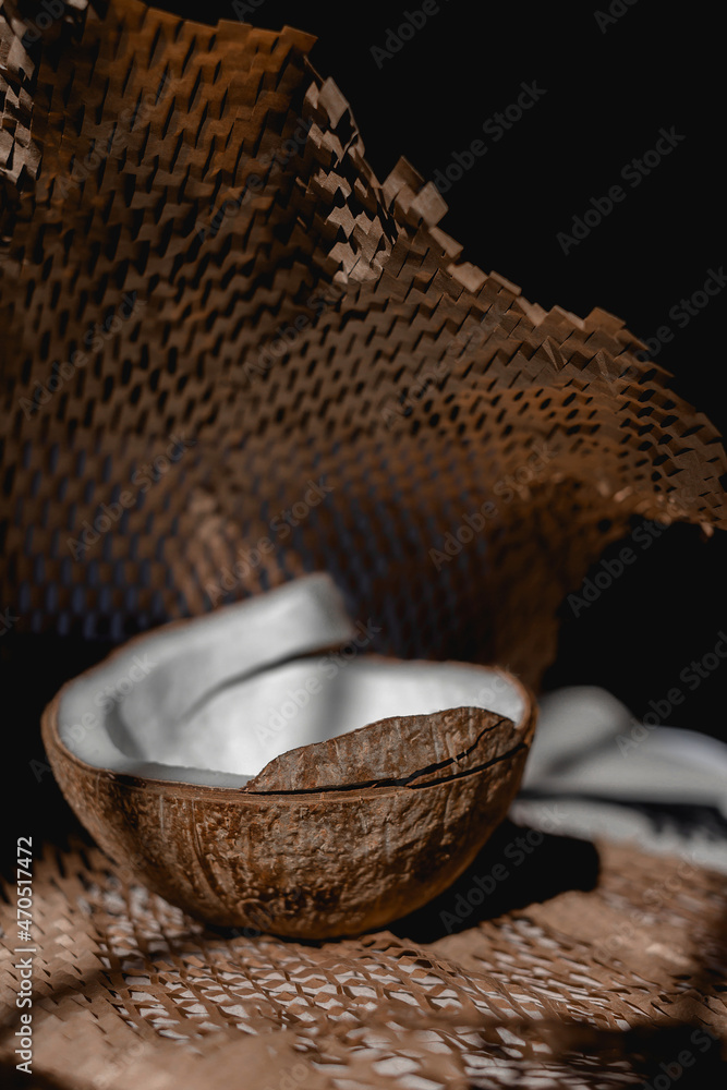 Fototapeta premium Half coconut on the table on paper. Front view.