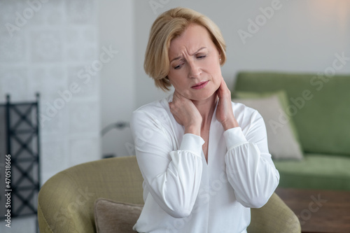 Photos Blonde woman feeling unwell while suffering from pain in neck